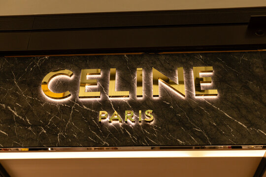 Singapore - January 27, 2026: Bright lights shine on the Celine sign in shopping mall in Singapore. Shoppers visit the space. The store showcases luxury items. It is busy day with many people around