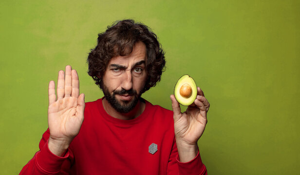 young adult bearded man with an avocado