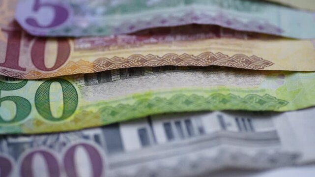A macro closeup pan clip of Saudi 5, 10, 50 and 200 Riyal bank notes.