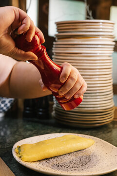 Grinding fresh pepper onto an omelet for breakfast