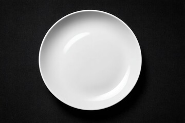 Empty white round plate on a black surface, simple and clean
