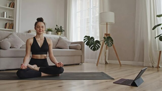 Young woman achieving inner peace through mindful meditation in a serene home environment, practicing yoga for physical and mental well-being with a tranquil smile