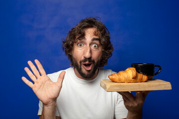young adult bearded man with a french breakfast