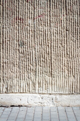 Naklejka premium Gray lined stucco street wall and a pavement