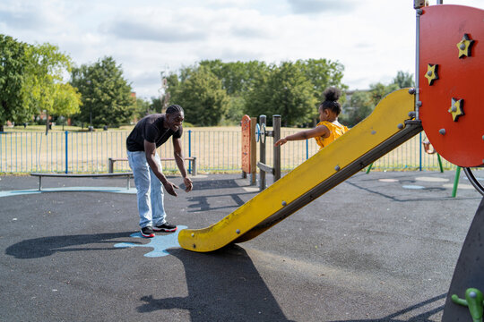Father with daughter sliding on a playground