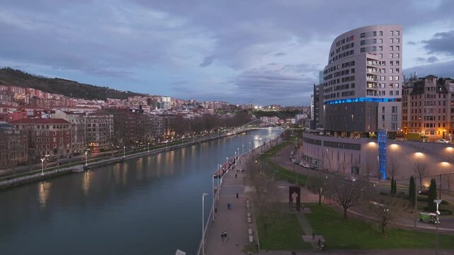 Night video from La Salve Bridge showing the Nervion River promenade and modern and historic buildings.