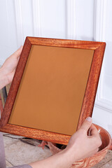 In the decorative background, a woman is holding a picture frame.