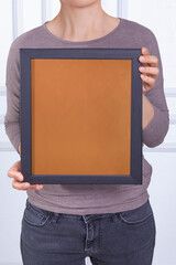 In the decorative background, a woman is holding a picture frame.