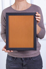 In the decorative background, a woman is holding a picture frame.