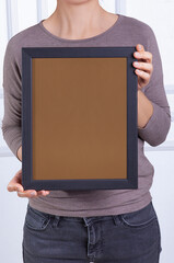 In the decorative background, a woman is holding a picture frame.