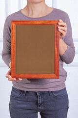 In the decorative background, a woman is holding a picture frame.
