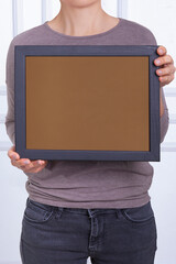In the decorative background, a woman is holding a picture frame.