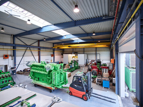 Fork-lift driver pulling gas engine out of factory shop floor