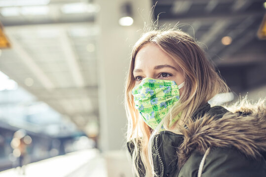Portrait of young woman wearing mask at station platform