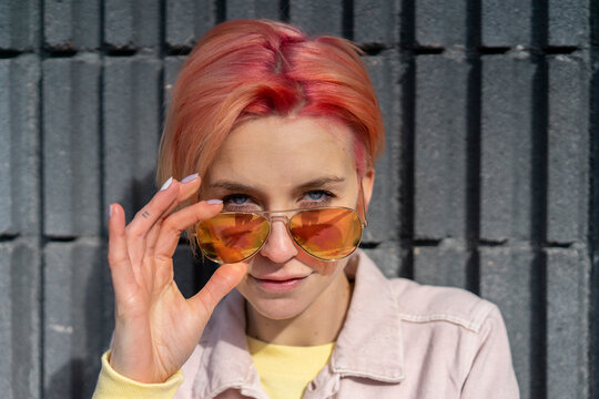 Portrait of young woman, sun glasses and pink jeans jacket