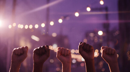 Five diverse female hands raised in clenched fists against a soft sunset bokeh background. A powerful symbol of women's rights, solidarity, and the fight for equality.