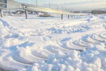 Tire tracks in the snow on an unplowed road.