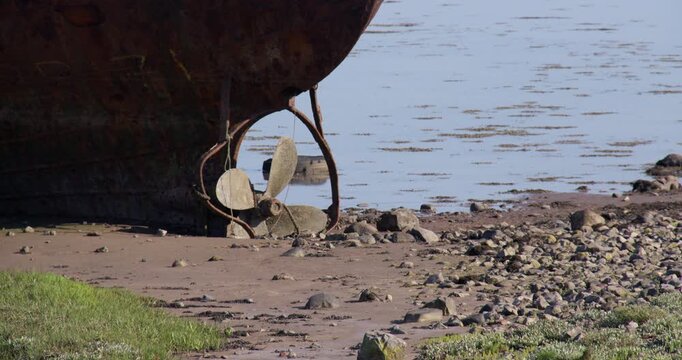 mid shot of a Abandoned dialect wreck fishing boat showing the propellers at Roa Island, barrow in furness,