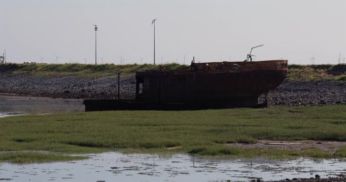 long shot of a Abandoned dialect wreck fishing boat at Roa Island, barrow in furness,