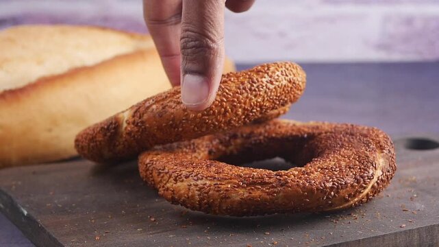 Fresh bagels and bread on wooden cutting board