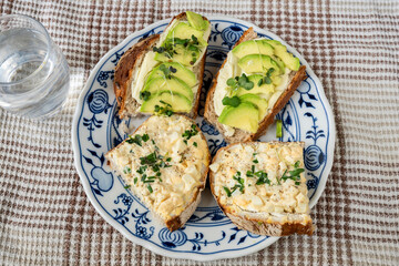 4 sliced bread with avocado and egg spread on plate.