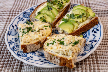 4 sliced bread with avocado and egg spread on plate.