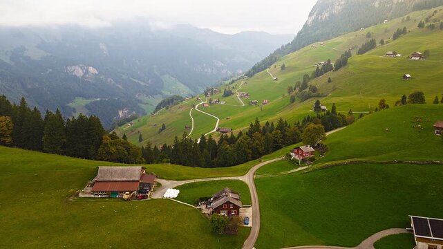 Cinematic drone shot of alpine Swiss village with mountains, 4K