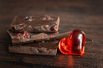 Delicious, dark chocolate with a red heart on a dark background for Valentine's Day