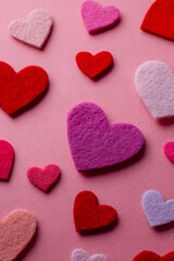 Fototapeta premium Colorful felt hearts on pink background for Valentine's Day