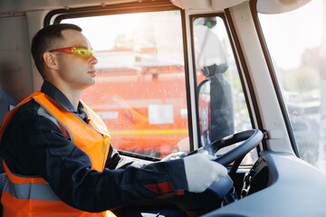 Happy caucasian male young adult driving truck with safety gear, sunlight