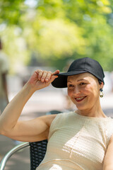 Woman smiling while pulling a baseball cap