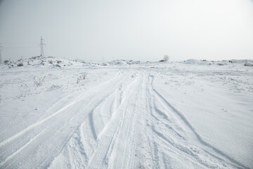 Obraz premium Car tire tracks in snow at winter.