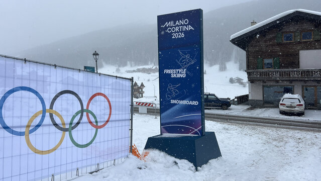 Livigno, Italy - February 4, 2026: Milano Cortina 2026 Winter Olympics signage for freestyle skiing and snowboard with Olympic rings in snowy alpine village