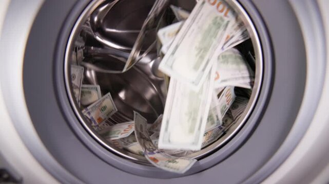 Hundred United States Dollar banknotes inside washing machine for money laundering and fraud concept.