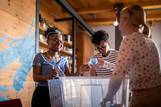 Diverse friends sorting plastic for recycling at home