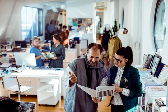 Coworkers reviewing design proofs in a creative office