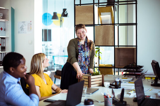Colleagues welcoming new hire in modern office