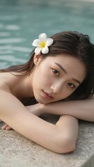 Beautiful young woman relaxing by swimming pool with flower in hair tropical spa vacation lifestyle concept