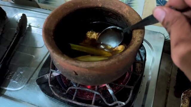boiling traditional drinks using a clay pot on the stove.