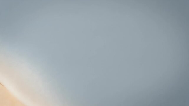 Gentle wave lapping on sandy shore, soft light, serene, abstract