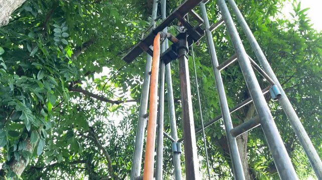 Upward view of tall drilling pipes extending into the sky, emphasizing scale, structure, and engineering effort in water well construction. This footage conveys strength, progress, and technical capab