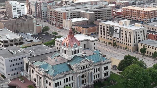 Zoom Aerial shot of Downtown Green Bay at golden hour with City Hall, Fox River and large Ship in the distance.