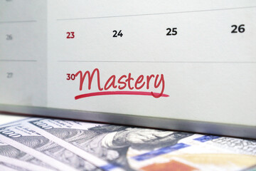 calendar with the word Mastery handwritten in red ink, centered on a background of scattered US one hundred dollar currency.