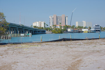 Naklejka premium Blue Draw Bridge Over Calm Water With Tower, Tree, and Waterfront Walkway between St. Pete Beach and South Pasadena, FL. Arches over calm water beside a control tower, with a prominent tree in the for