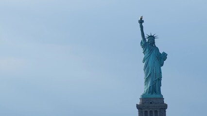 Iconic statue of liberty standing tall over new york city skyline symbolizing freedom, hope, and democracy under a clear blue sky © DawDunia