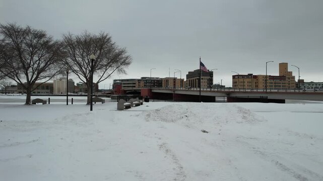 Slow and Low Drone push shot of American Flag Pole on the Rox River on a winter day in Green Bay Wisconsin.
