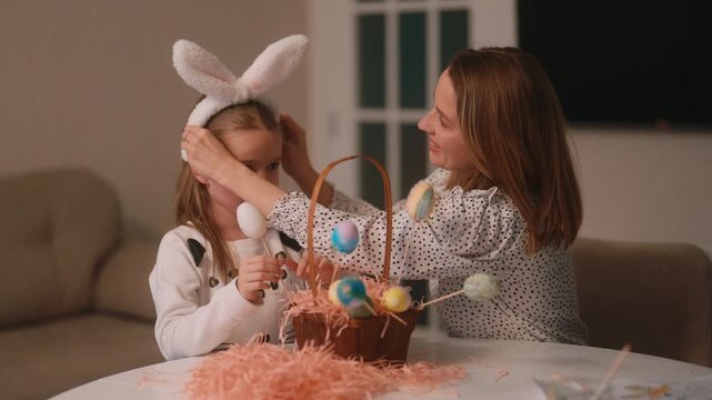 Mother and Daughter Decorating Easter Eggs and Wearing Bunny Ears Together