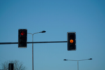 Red traffic light against a blue sky