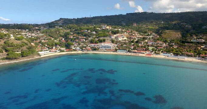 Aerial view of the beach of Santa Maria di Ricadi, a tourist destination in the province of Vibo Valentia, Calabria, Italy. Panorama of a turquoise bay, bordered by a sandy beach and a hillside town.