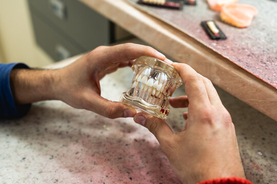 A dental technician creates a denture model in a dental office.